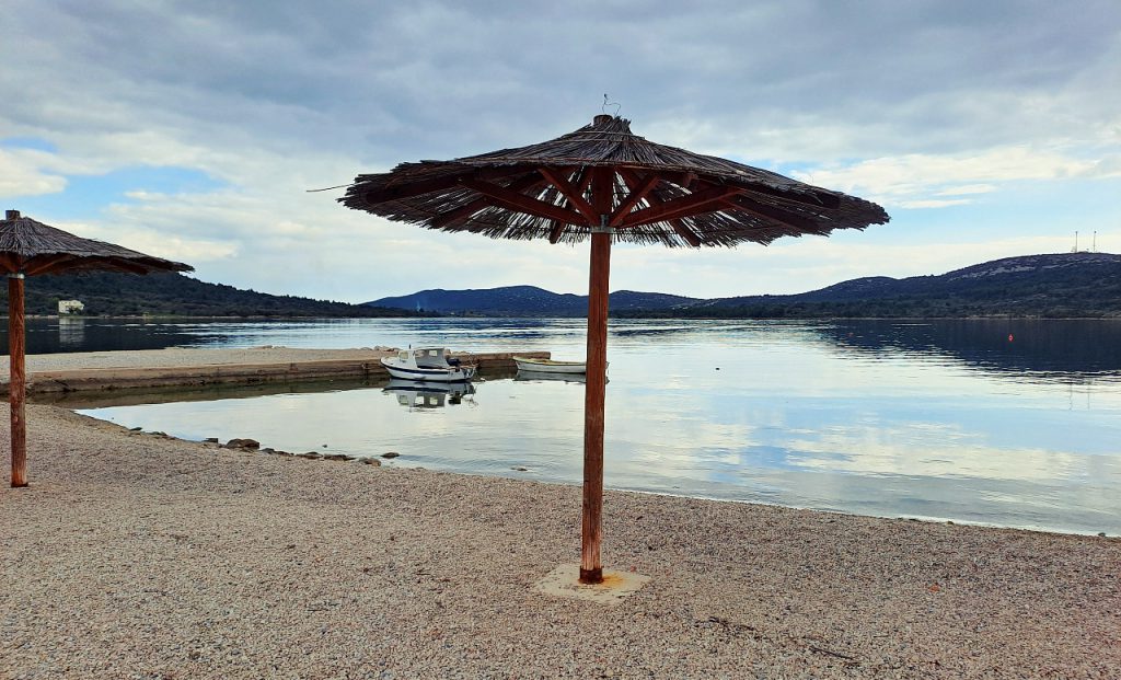 Kiesstrand mit Sonnenschirm in Dalmatien